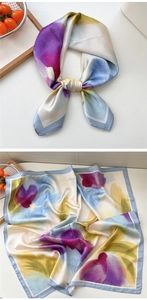 Detailed close-up of a colorful abstract floral print silk scarf with glossy texture
