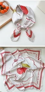 Detail of silk square scarf with red cherry print and polished satin texture