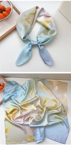 Detail of artistic gradient silk scarf tied in a bow showing smooth satin texture