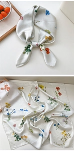 Detailed view of white floral silk scarf with colorful wildflower print and satin finish