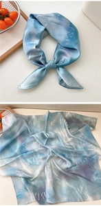 Detail of silk scarf showing smooth satin texture and blue gradient artistic letters
