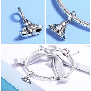 Detailed view of S925 sterling silver bird charm with blue cubic zirconia on a bracelet