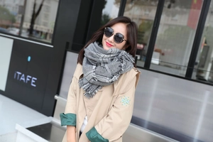 Detail showing high-quality grey houndstooth scarf texture with long fringe tassels