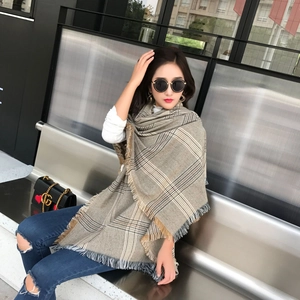 Detail of soft winter scarf with classic houndstooth pattern and refined fringe edge