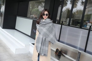 Detailed view of the thick fabric texture and handmade tassels on the houndstooth scarf