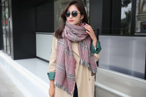 Detail of classic plaid oversized shawl scarf with soft fringe trim and colorful grid pattern