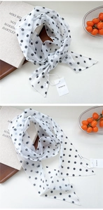 Détail du foulard en soie à pois blancs avec étiquette de marque et texture mousseline