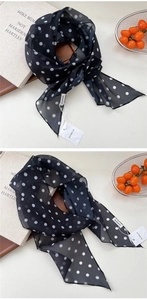 Vue détaillée du foulard en soie à pois noirs avec une texture mousseline transparente