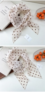 Gros plan d'un foulard à pois vintage léger avec étiquette sur un plateau en bois rustique