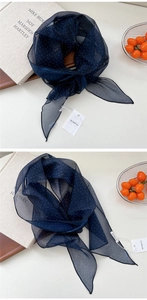 Détail d'un foulard en soie bleu marine à pois légers avec étiquette de marque chic