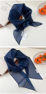 Détail du foulard en mousseline bleu marine à pois montrant sa texture légère et son bord