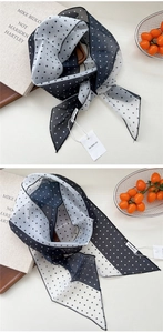 Vue détaillée d'une écharpe légère à pois noirs et blancs avec couture fine du bord