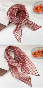 Détail d'un foulard en soie à pois avec des accessoires lifestyle sur surface blanche