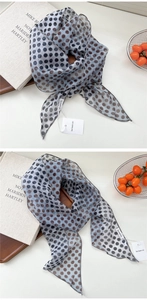 Gros plan sur un foulard en mousseline bleu clair léger à pois avec bords cousus fins