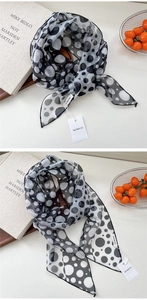 Détail d'un foulard en soie à pois noirs et blancs avec texture mousseline légère