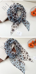 Gros plan détaillé du foulard en mousseline à pois bleu clair avec étiquettes de marque