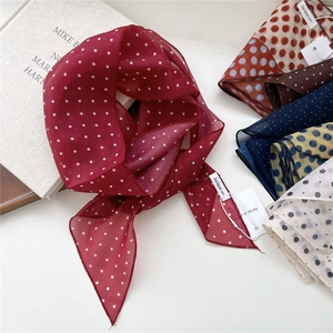 Foulard léger en soie à pois bordeaux avec divers coloris sur fond de livre décoratif
