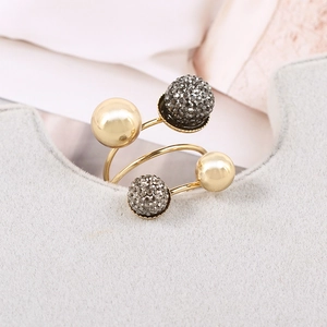Macro shot of spiral gold brass ring featuring two polished balls and two crystal-studded spheres