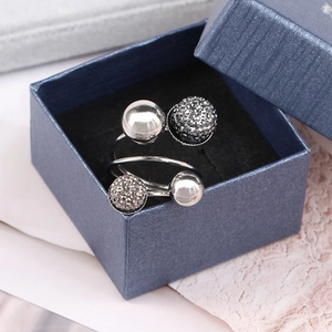 Detailed close-up of a silver spiral ring featuring two polished and two pavé beads