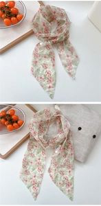 Detail of floral chiffon scarf with light green base and delicate pink flower patterns