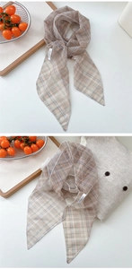 Detail of checkered mesh scarf featuring refined edge stitching and a premium brand label