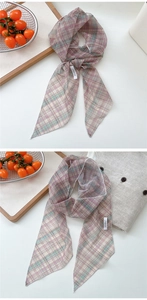 Close-up of elastic mesh plaid skinny scarf with DN&KW woven label on a table