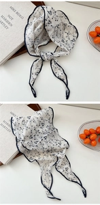 Dettaglio di sciarpa in cotone e lino con stampa floreale e cuciture blu sottili