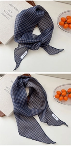 Détail de l'écharpe en lin à rayures bleues montrant les bords ondulés et le tissu léger