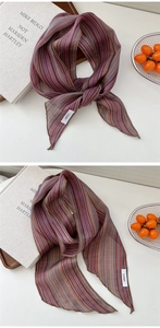 Détail d'une écharpe légère en lin à rayures colorées montrant texture et étiquette