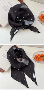 Gros plan du foulard léger en lin noir à pois blancs avec des bordures surpiquées