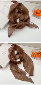 Détail d'un foulard fin en lin marron à pois avec des extrémités en diagonale