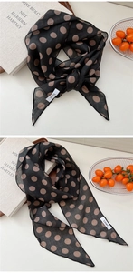 Gros plan sur un foulard léger en lin noir à pois marron avec coutures détaillées