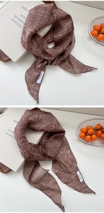 Détail d'une écharpe rayée marron vintage avec une étiquette cousue en lin blanc sur le tissu