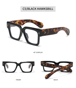 Detail of square oversized frames in black with tortoiseshell temples and gold hinges