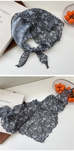 Close-up of black floral lace triangle scarf with detailed crochet mesh and scalloped edges