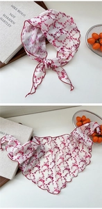Detail of white floral chiffon neck scarf with red pattern and wavy stitched edges