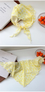 Detail of yellow floral neck scarf with elegant wavy stitched edges and soft fabric