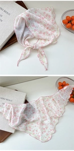 Detailed shot of lightweight chiffon scarf with pink floral pattern and stitched edges