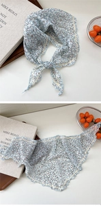 Detail of light blue floral neck scarf with wavy stitched edges and breathable fabric