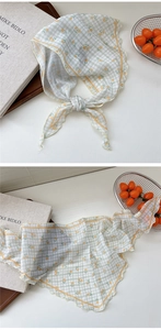 Detailed macro view of lightweight floral triangle scarf with vintage green check pattern