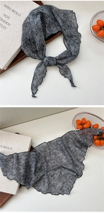 Close-up of black floral lace triangle scarf with delicate scalloped edges and mesh texture