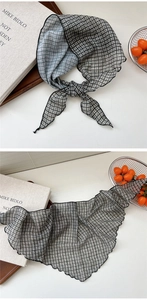 Detail of lightweight black and white houndstooth neck scarf with delicate rolled edges