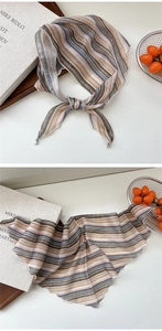 Detail of striped chiffon scarf featuring delicate ruffled edges and elegant brown tones