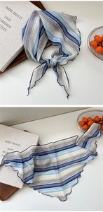 Detail of blue striped chiffon scarf with wavy edges and soft lightweight texture