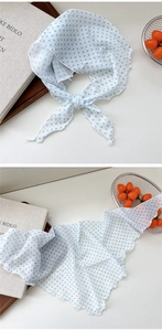 Macro shot of lightweight light blue polka dot scarf featuring delicate wavy rolled edges