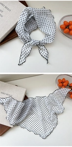 Close-up of lightweight white floral scarf with black polka dots and wavy edge details