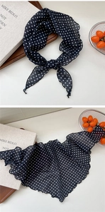 Detail of thin black chiffon neck scarf with white polka dots and wavy hem edges