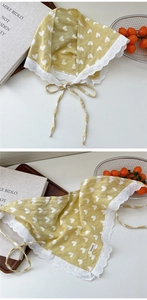 Close-up of yellow linen triangle scarf with white heart prints and lace edge details