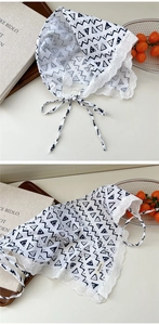 Detail of white cotton scarf with black geometric patterns and delicate lace trimming edge
