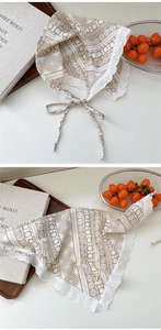 Close-up of beige geometric print scarf with delicate white lace trim and tie details